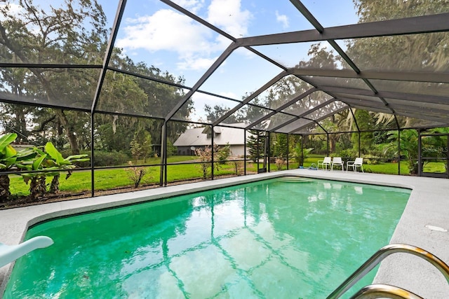 pool with a lanai, a yard, a water slide, and a patio