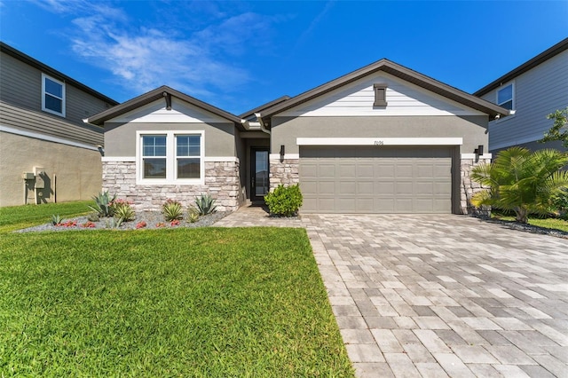 view of front facade with a garage, stone siding, decorative driveway, stucco siding, and a front yard