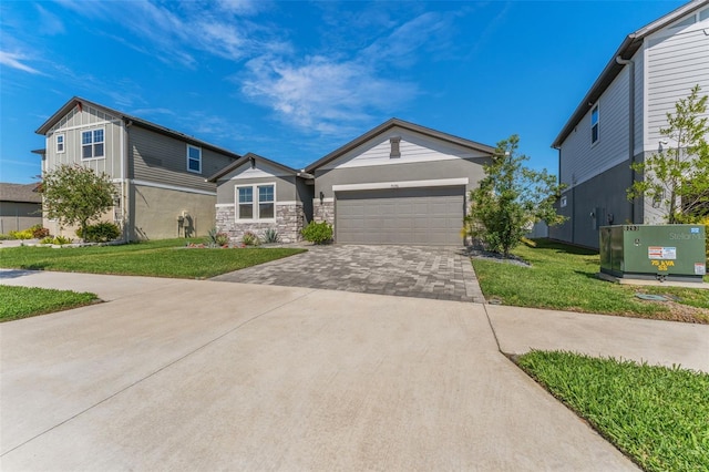 view of front of home featuring a garage, stone siding, decorative driveway, a front lawn, and board and batten siding