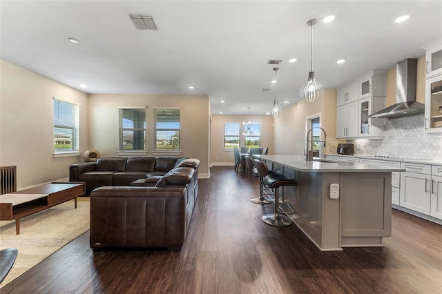 living area featuring dark wood-style floors, baseboards, visible vents, and recessed lighting