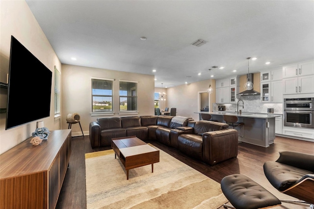 living area with dark wood finished floors, visible vents, and recessed lighting