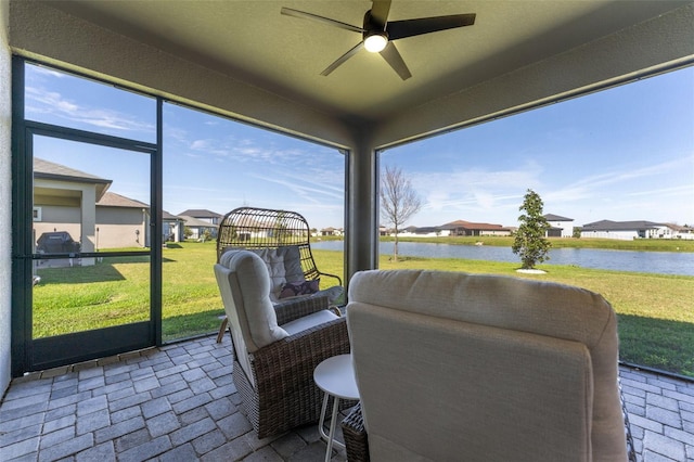 sunroom / solarium featuring a water view, ceiling fan, and a wealth of natural light