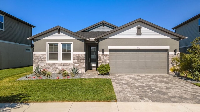 view of front of house with decorative driveway, stone siding, a front lawn, and a garage