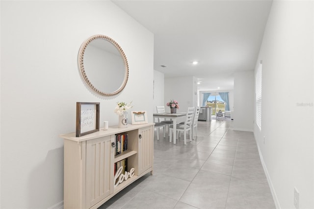 hall featuring recessed lighting, light tile patterned flooring, and baseboards