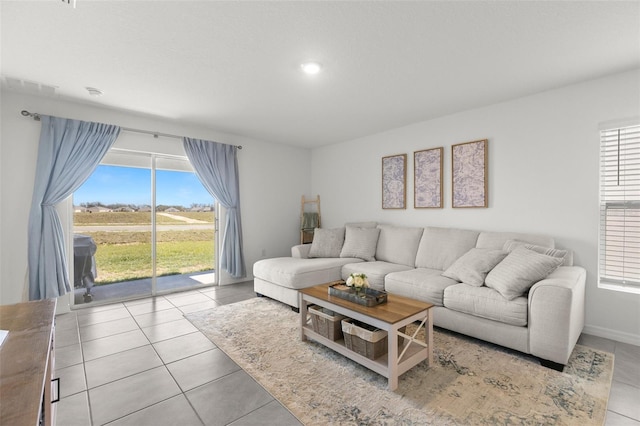 living room featuring plenty of natural light, baseboards, and tile patterned floors