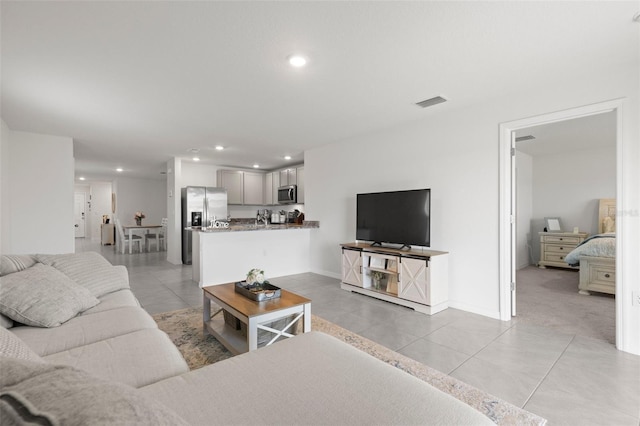 living area featuring light tile patterned floors, baseboards, visible vents, and recessed lighting