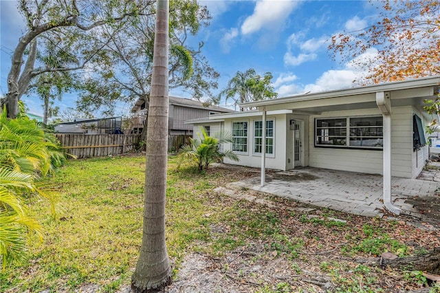 back of property with a patio, a lawn, and fence