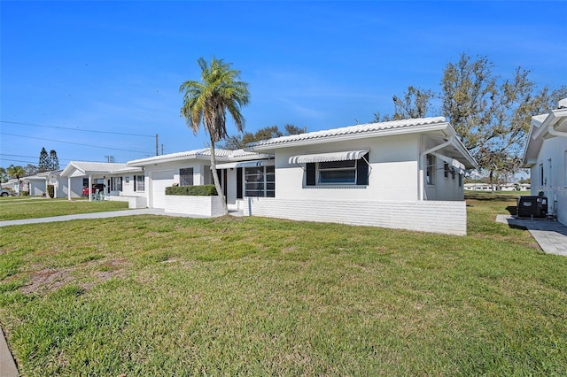 view of front of property featuring a front yard, concrete driveway, an attached garage, and stucco siding