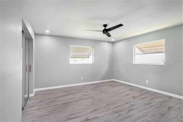 empty room with a healthy amount of sunlight, baseboards, and wood finished floors