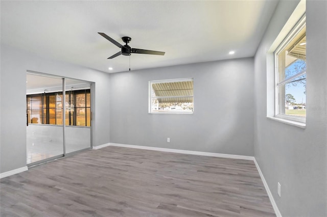 empty room featuring recessed lighting, wood finished floors, a ceiling fan, and baseboards