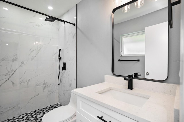 bathroom with toilet, a marble finish shower, vanity, and recessed lighting