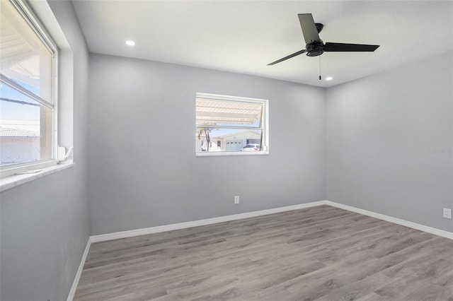 unfurnished room with recessed lighting, wood finished floors, a ceiling fan, and baseboards