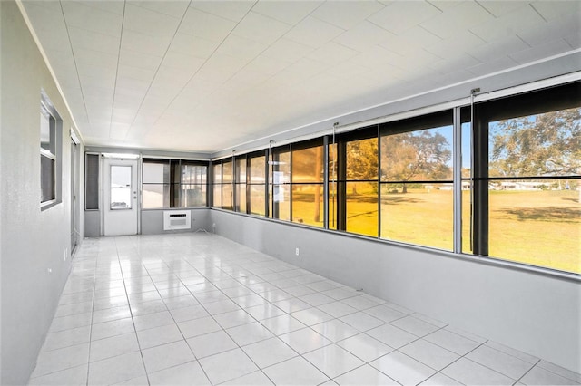 unfurnished sunroom featuring plenty of natural light and a wall unit AC