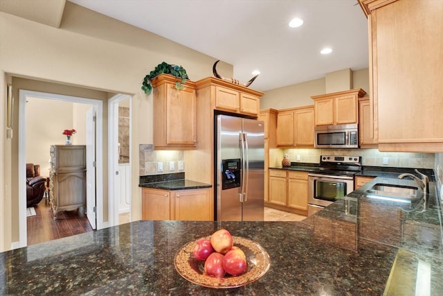 kitchen with stainless steel appliances, recessed lighting, decorative backsplash, light brown cabinetry, and a sink