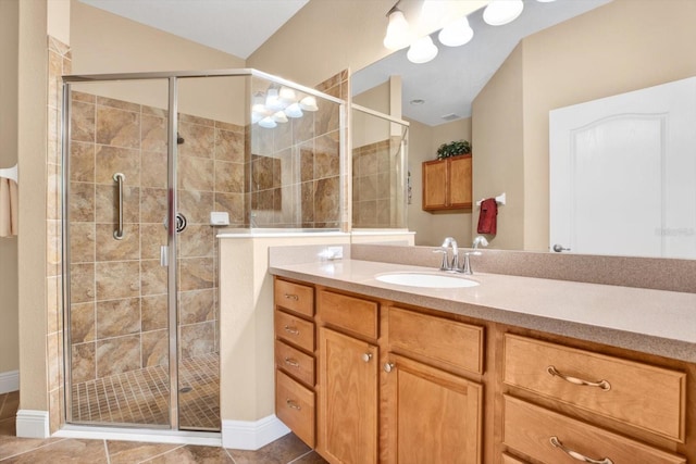 bathroom with tile patterned flooring, vaulted ceiling, a shower stall, and vanity