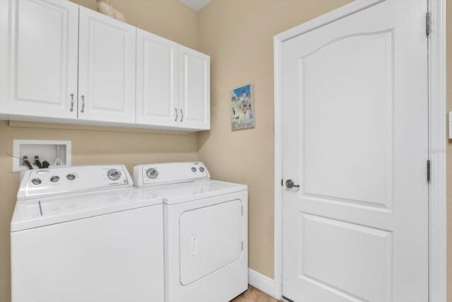 washroom with washing machine and dryer, cabinet space, and baseboards