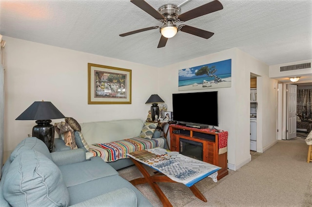 carpeted living area with a ceiling fan, baseboards, visible vents, and a textured ceiling