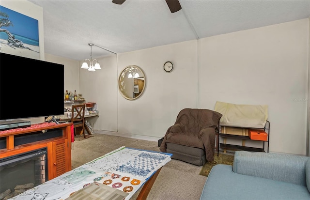 carpeted living room featuring a textured ceiling and ceiling fan with notable chandelier