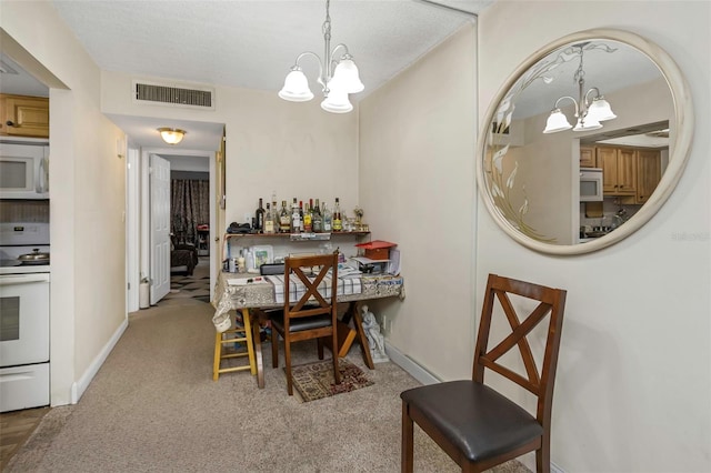 carpeted dining area featuring visible vents, a chandelier, and baseboards