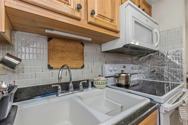 kitchen featuring white appliances, tasteful backsplash, dark countertops, brown cabinets, and a sink