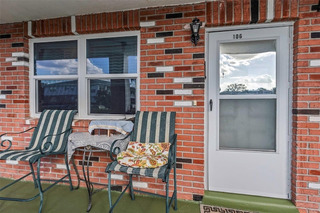 entrance to property featuring brick siding