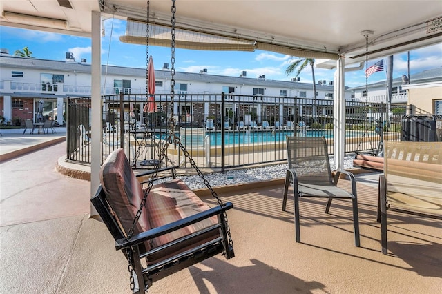 view of patio featuring a community pool and fence