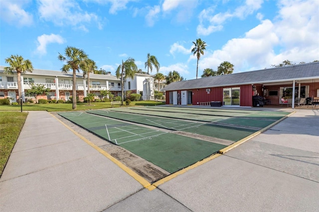 view of property's community featuring shuffleboard and a lawn