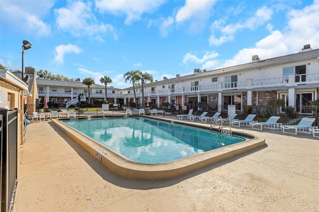 community pool featuring a patio area and fence