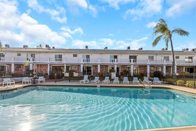 view of swimming pool featuring fence and a patio