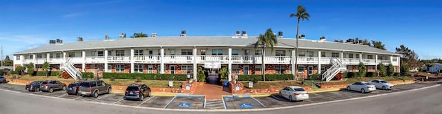 view of building exterior featuring stairs and uncovered parking