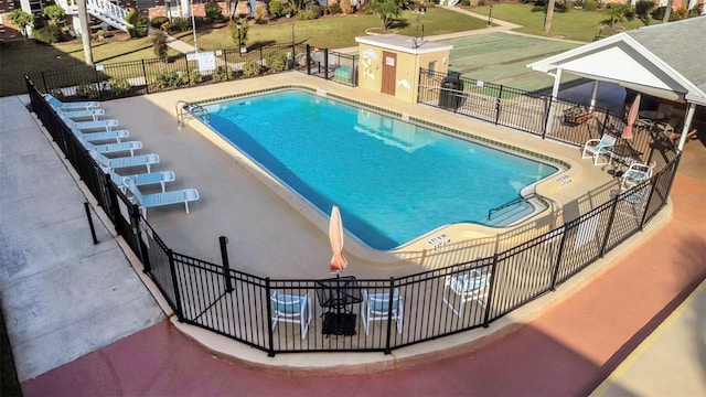 community pool with fence and a patio