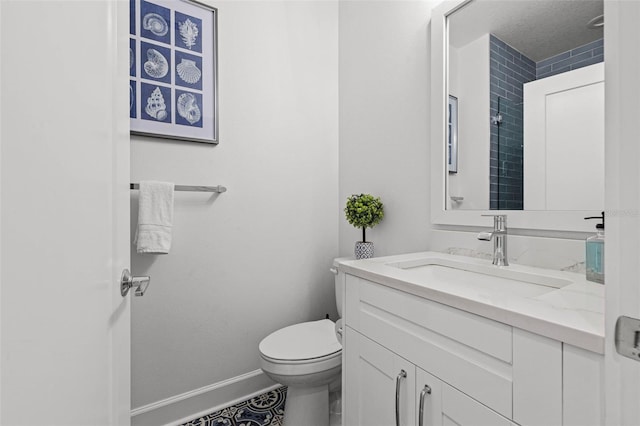 bathroom featuring toilet, baseboards, a textured ceiling, and vanity