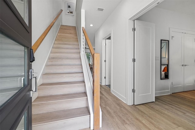 staircase featuring recessed lighting, visible vents, and wood finished floors