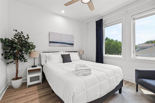 bedroom with a ceiling fan, baseboards, wood finished floors, and recessed lighting