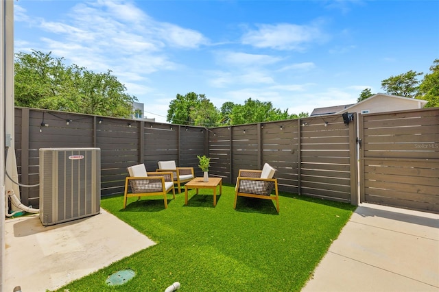 view of yard featuring central air condition unit, a fenced backyard, and a gate