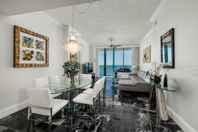 dining room featuring ornamental molding, marble finish floor, and a textured ceiling