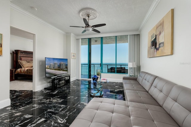 living room featuring marble finish floor, ornamental molding, a ceiling fan, a textured ceiling, and baseboards