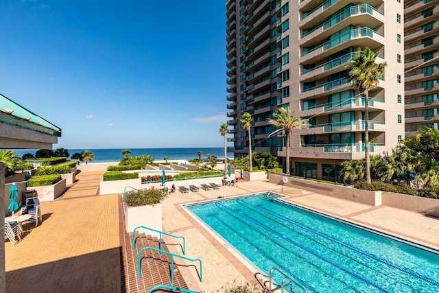 community pool featuring a water view and a patio