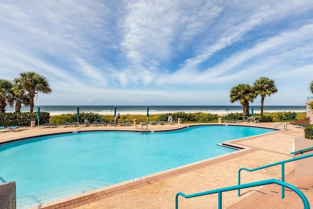 community pool with a water view and a patio