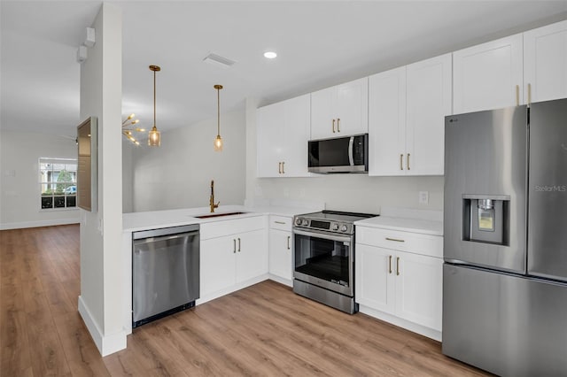 kitchen featuring light wood finished floors, stainless steel appliances, a sink, and light countertops