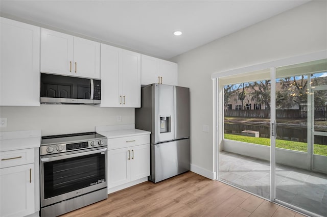 kitchen with white cabinetry, appliances with stainless steel finishes, and light countertops