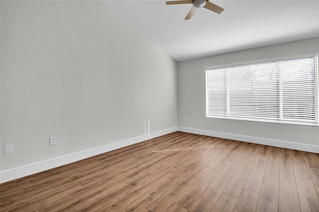 unfurnished room featuring ceiling fan, baseboards, vaulted ceiling, and wood finished floors