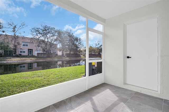 unfurnished sunroom with a water view