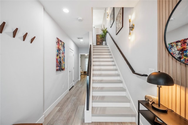 stairway with recessed lighting, baseboards, and wood finished floors