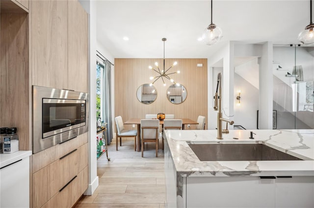 kitchen featuring light brown cabinetry, stainless steel microwave, and modern cabinets