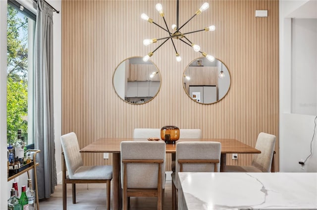 dining room with wood finished floors and a notable chandelier