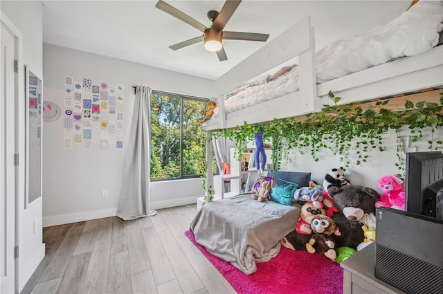 bedroom with wood finished floors, a ceiling fan, and baseboards