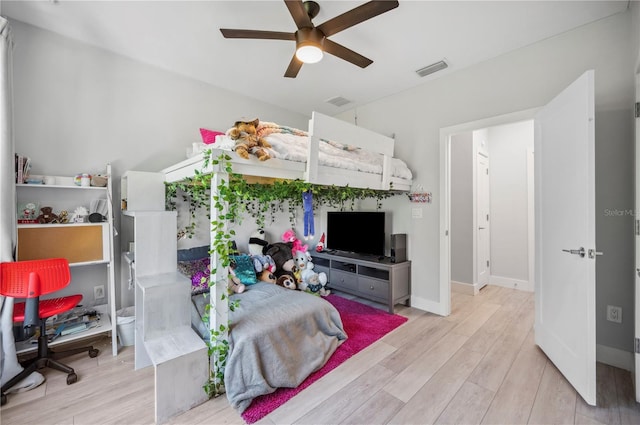 bedroom with baseboards, visible vents, and wood finished floors