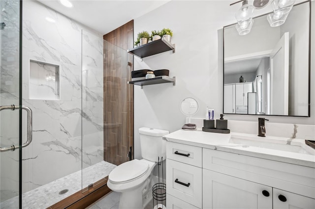 full bath with vanity, a marble finish shower, and toilet