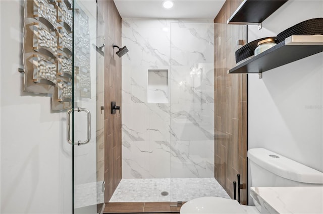 full bath featuring toilet and a marble finish shower